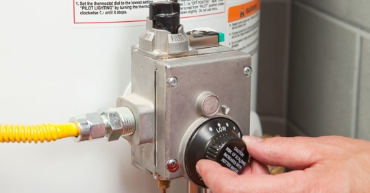 Homeowner changing the temperature on a water heater